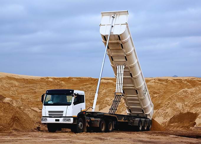White Dump Truck Unloading Sand