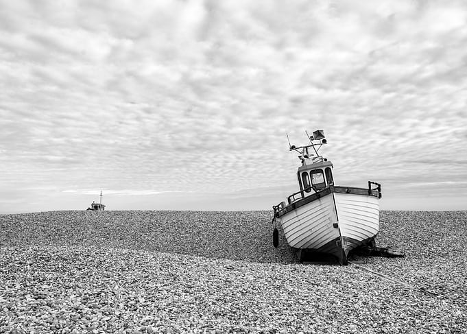 Black and White Boat on Pebble Beach
