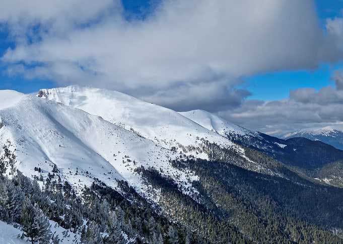 Snowy Mountain Range Under Cloudy Sky