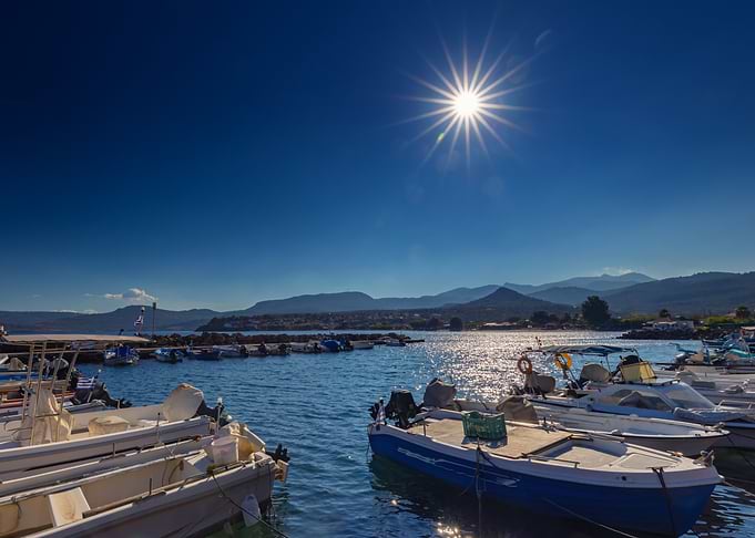 Boats in harbor under bright sun, Greek Island