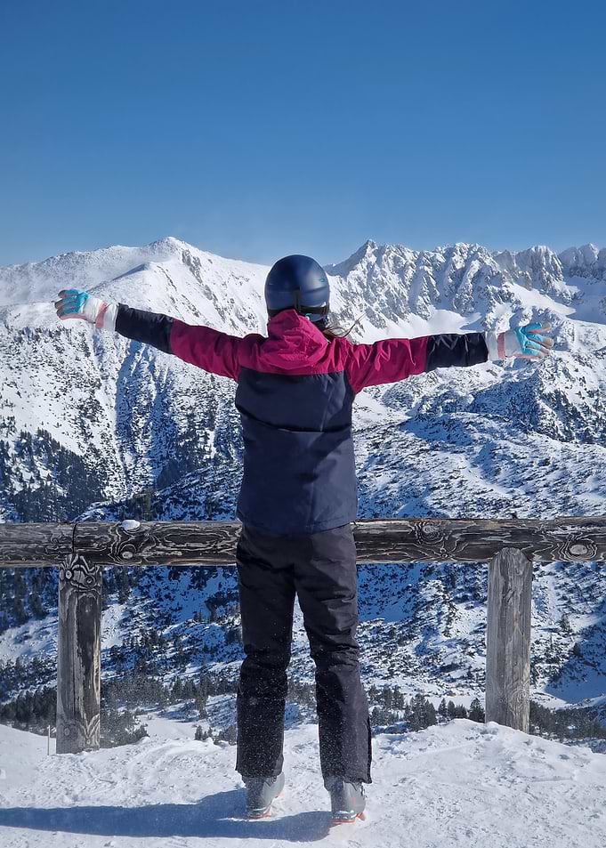 Skier with arms outstretched in mountains