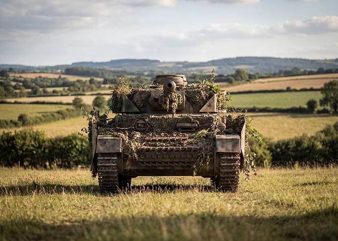 Camouflaged Tank in Grassy Field