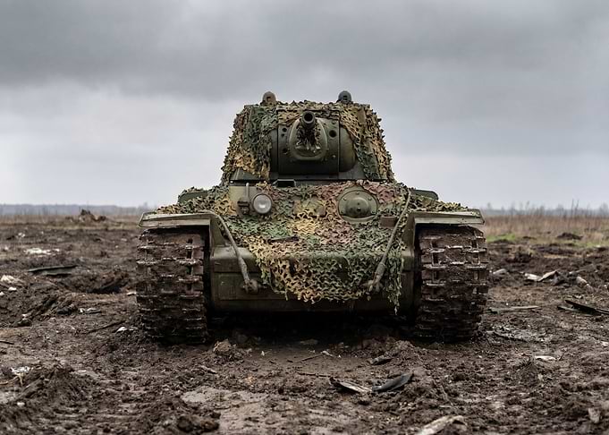 Camouflaged Tank in Muddy Field