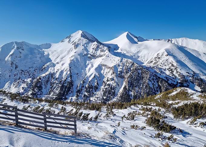 Snowy Mountain Peaks Under Clear Blue Sky