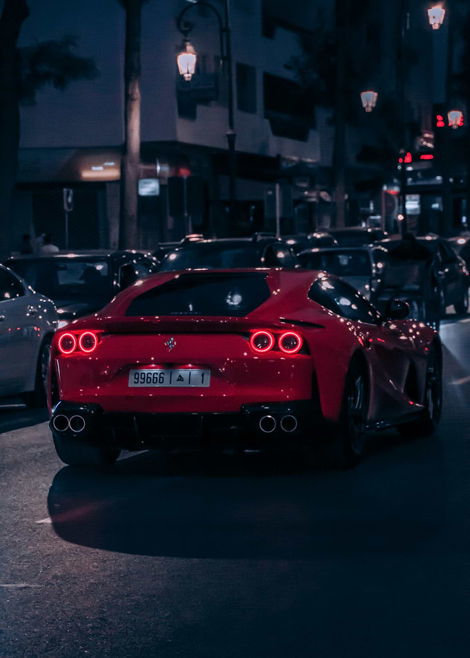 Red Ferrari on City Street at Night