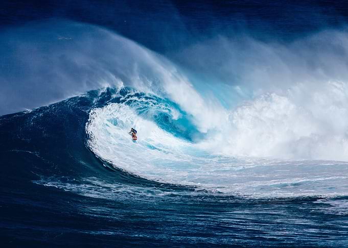 Surfer riding a massive ocean wave