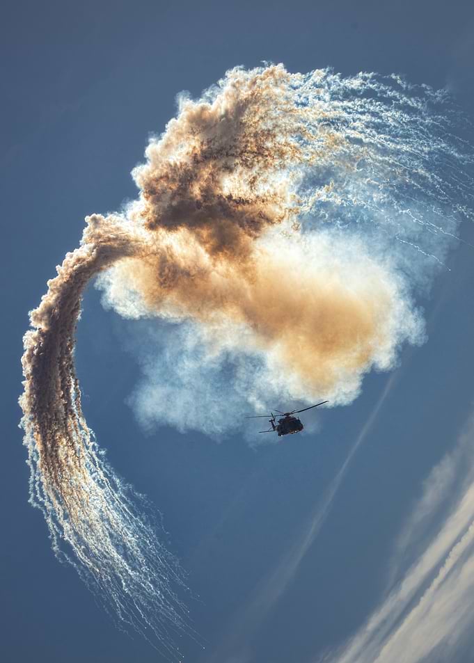Helicopter with Smoke Trail in Blue Sky