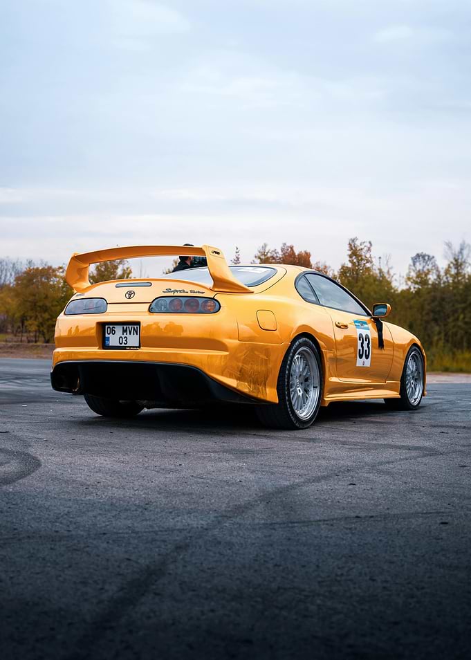 Yellow Toyota Supra on Asphalt