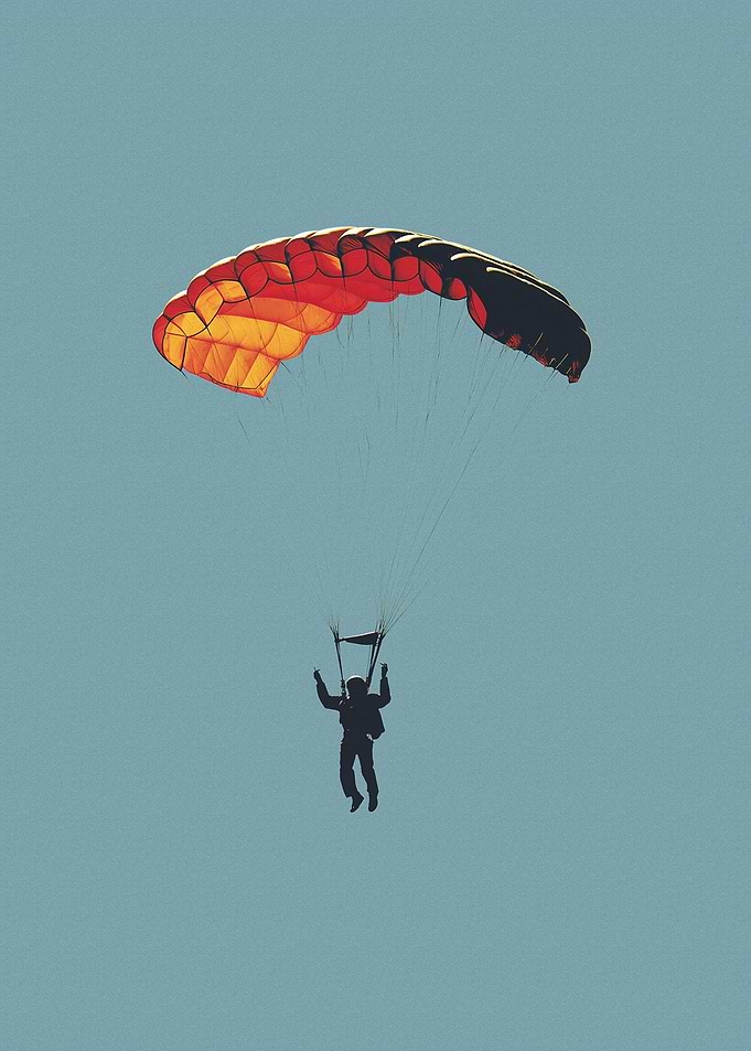 Skydiver with Parachute in Blue Sky