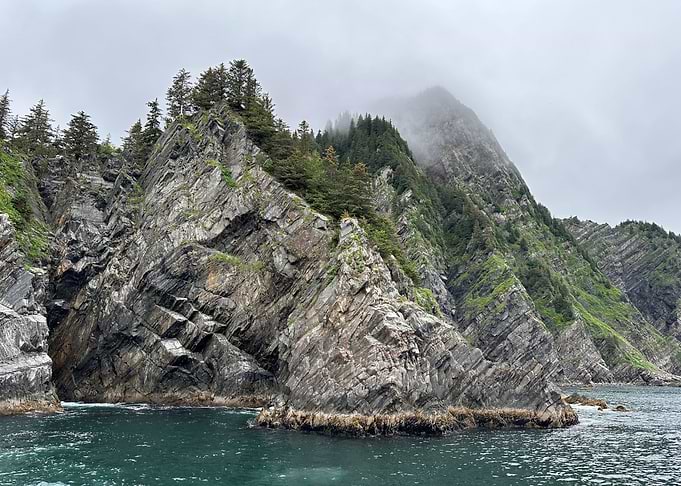 Rocky Alaska Coastline with Trees and Fog