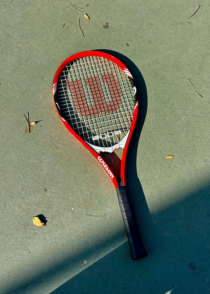 Red Wilson Tennis Racket on Court