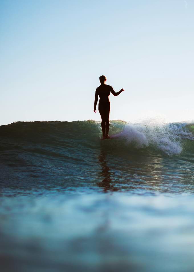 Surfer riding a wave at sunset