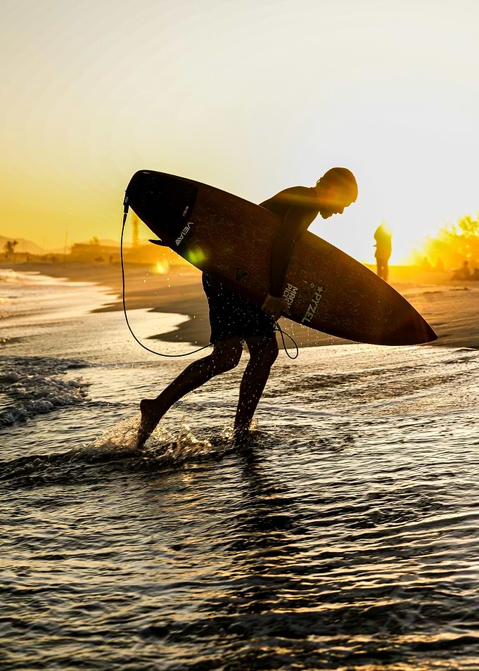 Surfer silhouette at sunset on beach