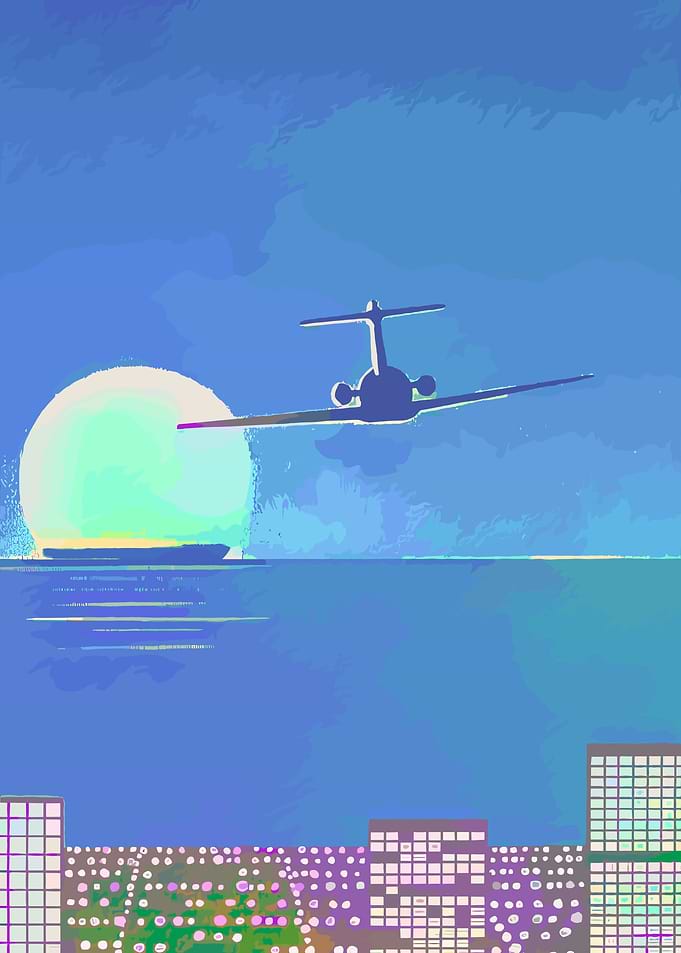 Airplane over city at sunset