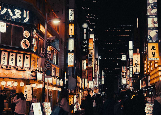 Nighttime Tokyo street with bright signs