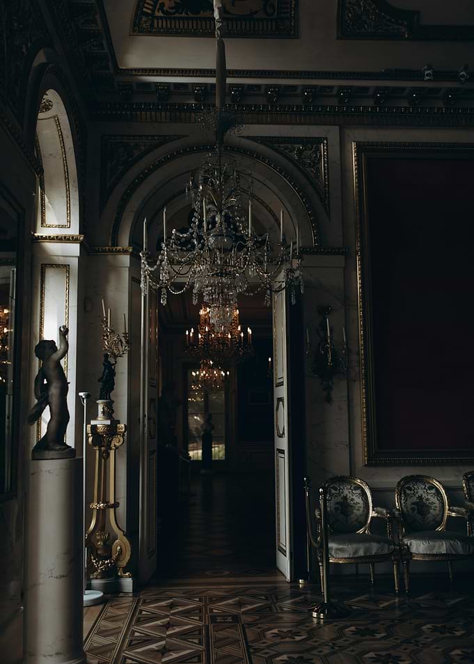 Ornate Hallway with Chandeliers and Statues