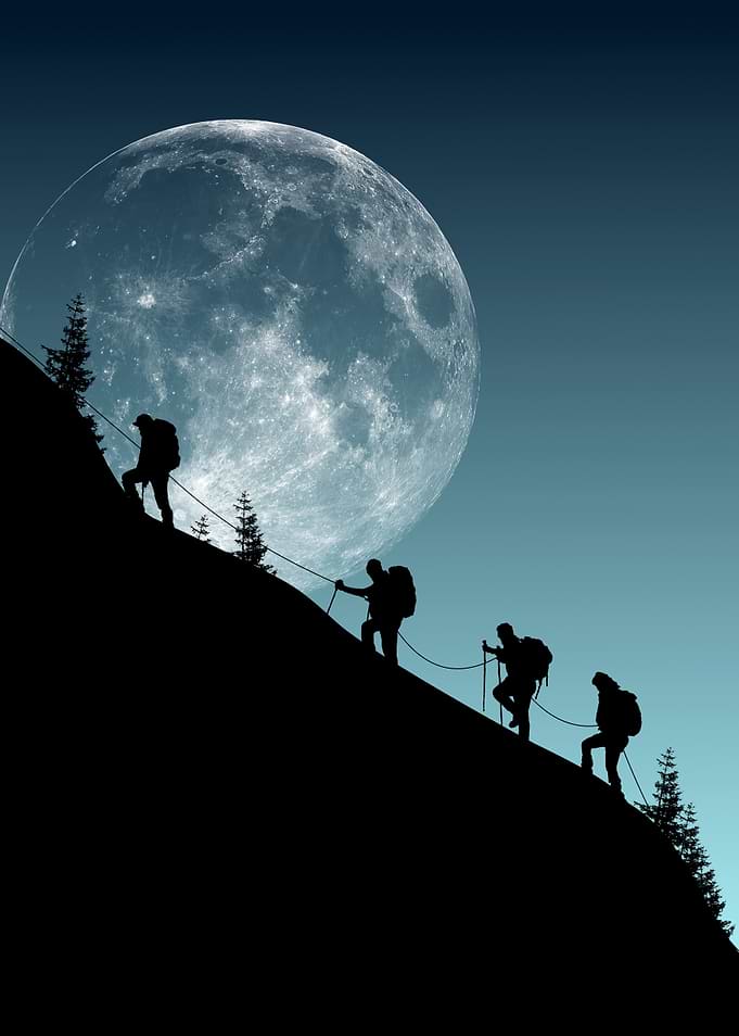 Hikers Silhouetted Against a Giant Moon