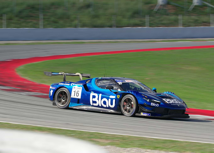 Blue Ferrari Race Car on Track