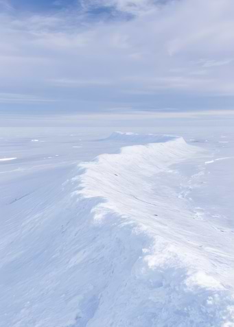 Snowy Mountain Ridge Under Pale Sky