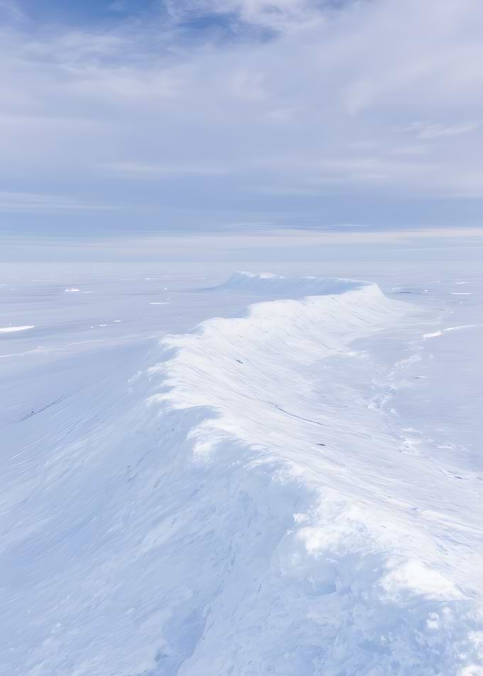 Snowy Mountain Ridge Under Pale Sky