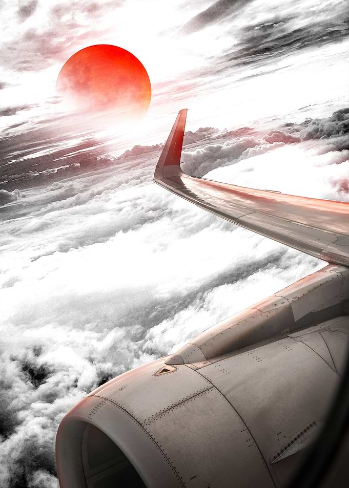 Airplane Wing View with Red Sun