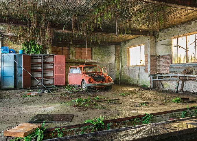 Abandoned VW Beetle in a derelict garage