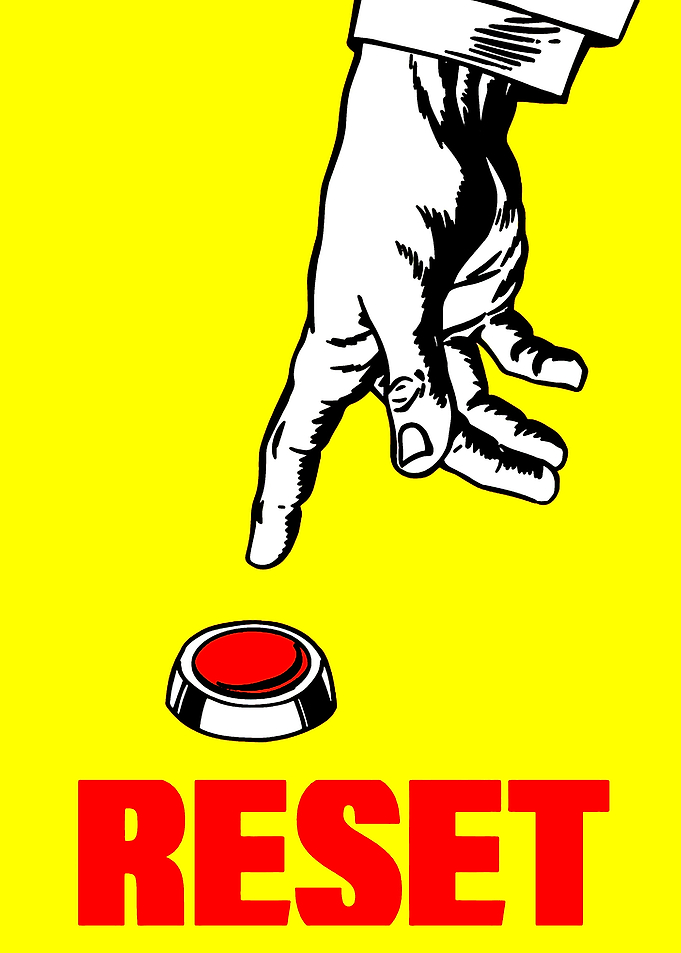 Hand pressing a red reset button