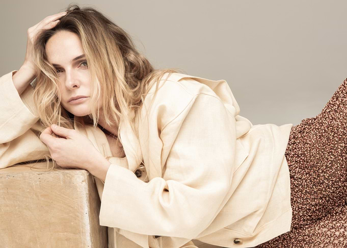 rebecca ferguson in beige jacket and patterned skirt