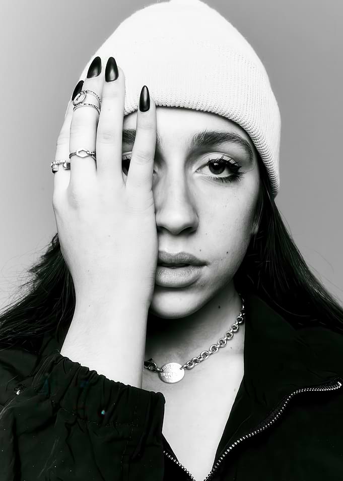 Woman in Beanie Covering Eye with Hand