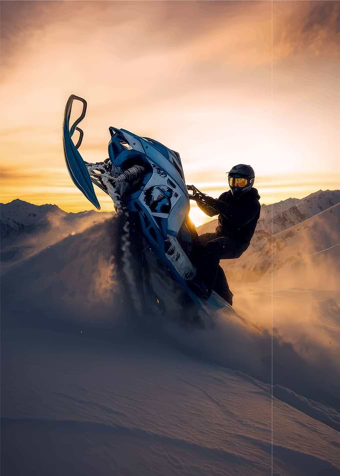 Snowmobiler performing a jump at sunset