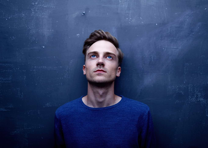 kenay spanish musician looking up against blue wall