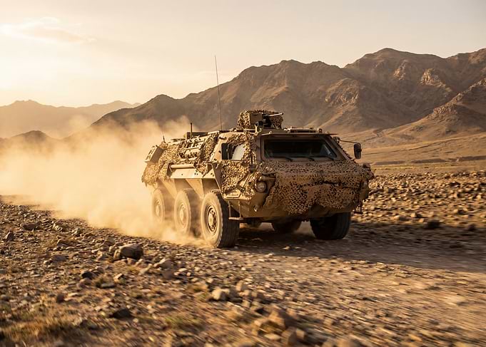 Armored Vehicle Driving Through Desert Dust