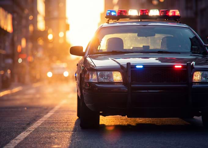 Police car with flashing lights at sunset