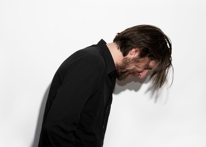 fennesz in black shirt with head down