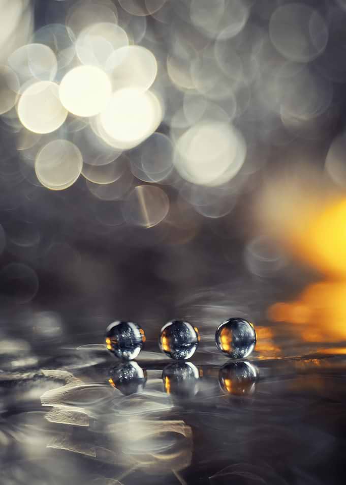 Three Glass Marbles on Reflective Surface