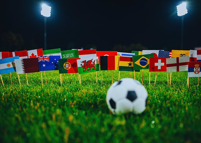 Soccer ball and international flags on grass