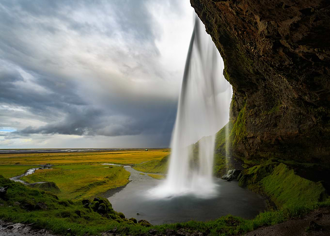 Iceland waterfall cascading into a pool with dramatic sky