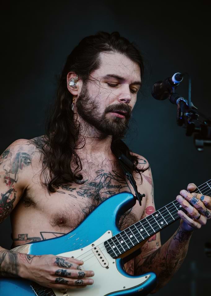 Tattooed musician playing guitar