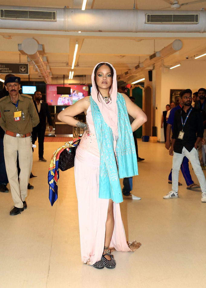 Rihanna in a pink dress and headscarf