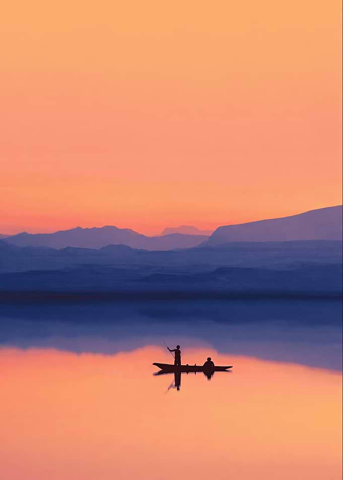 Silhouettes of people in a boat at sunset