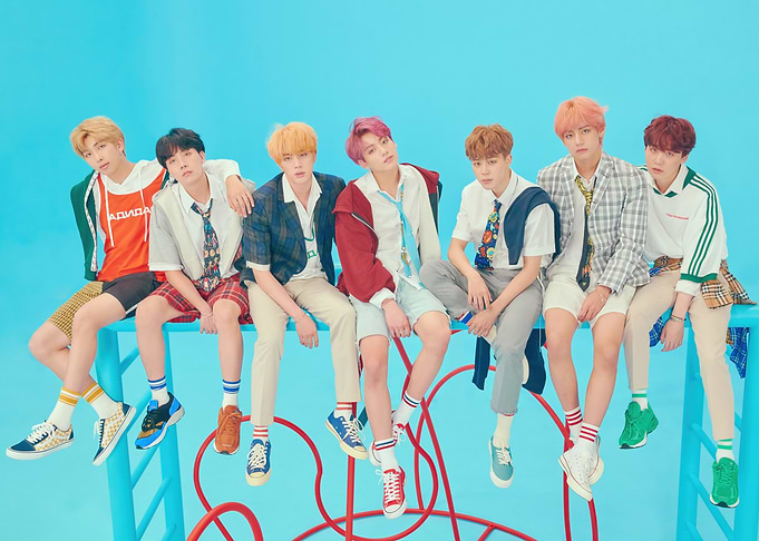 BTS members posing on a blue structure