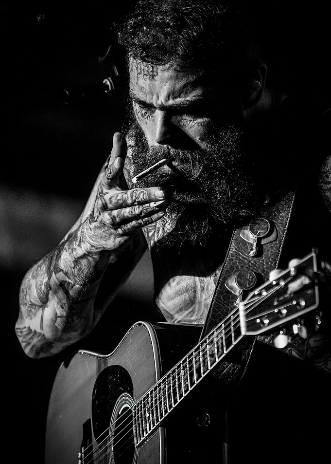 Man lighting cigarette with guitar