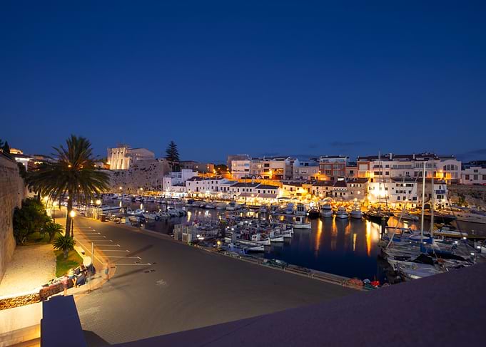 Nighttime harbor with boats and buildings