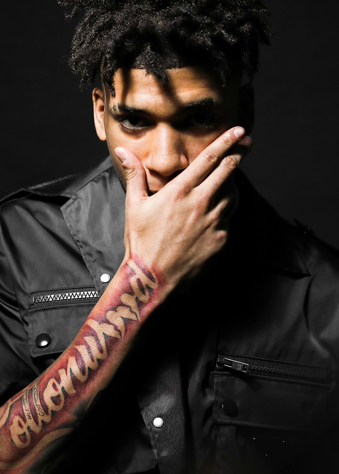 NLE Choppa with arm tattoo and hand over mouth