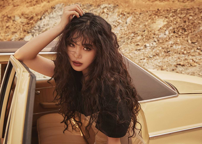 gi dle leaning on a car in a desert