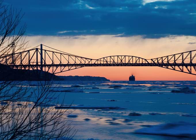 Bridge over icy water at sunset