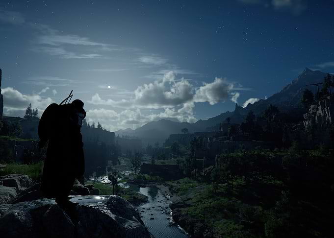 Lone figure overlooking a moonlit valley