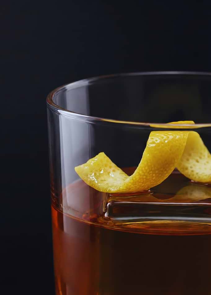 Amber Whiskey Cocktail with Lemon Twist in a Lowball Glass