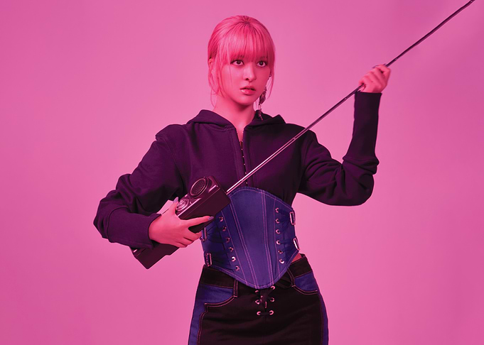 Lily nmixx with pink hair holding a radio