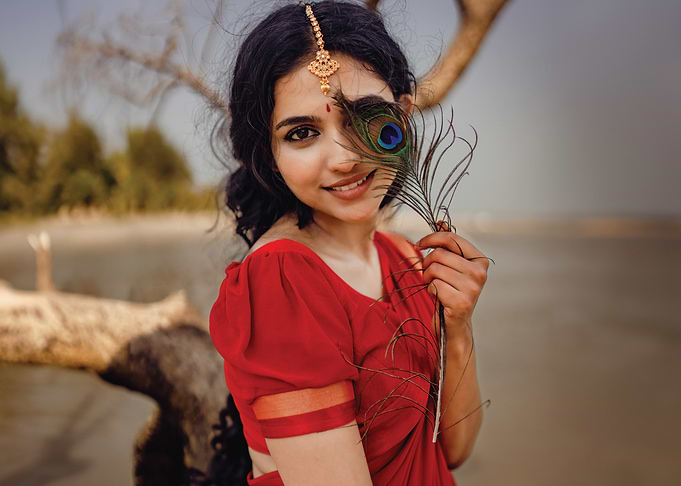 mamitha baiju in Red Saree with Peacock Feather